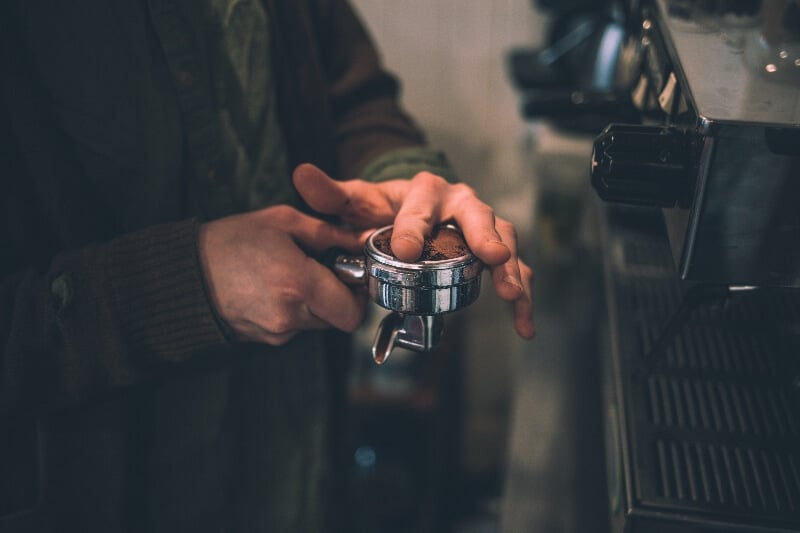 Man tamping coffee for espresso