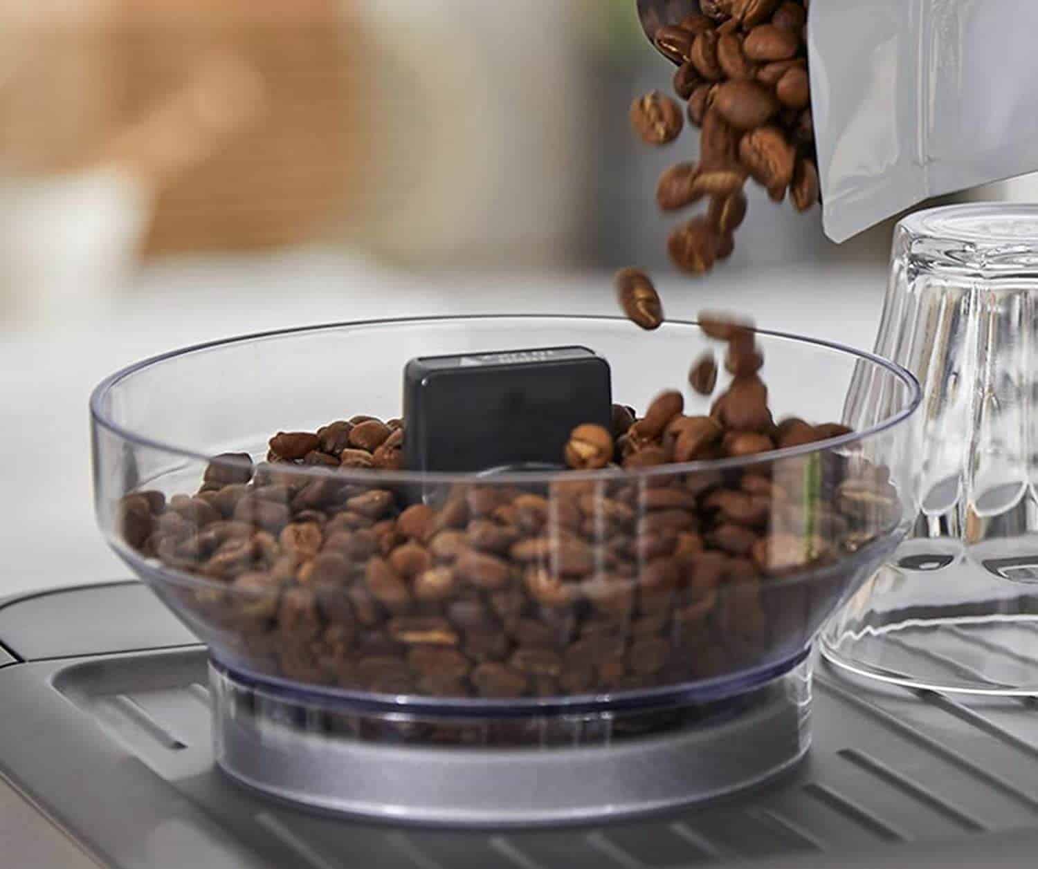 adding coffee beans to a grinder in an espresso maker with built in grinder 